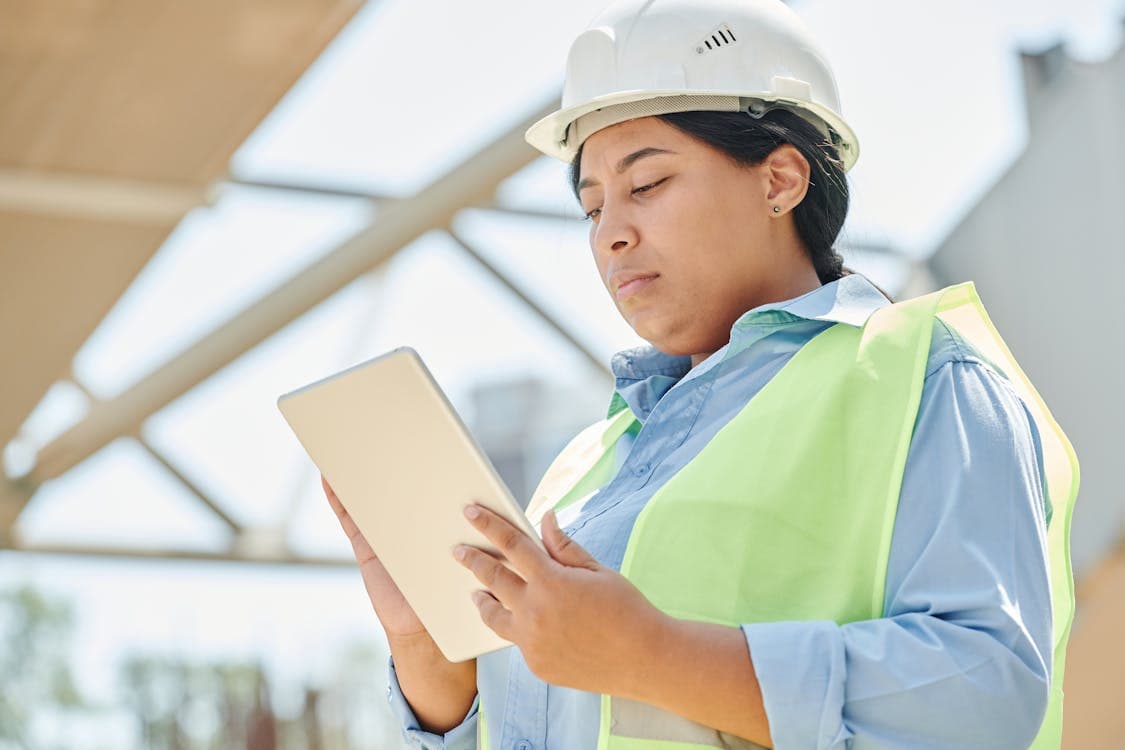 Engineer using a digital tablet to complete an equipment inspection on a construction site