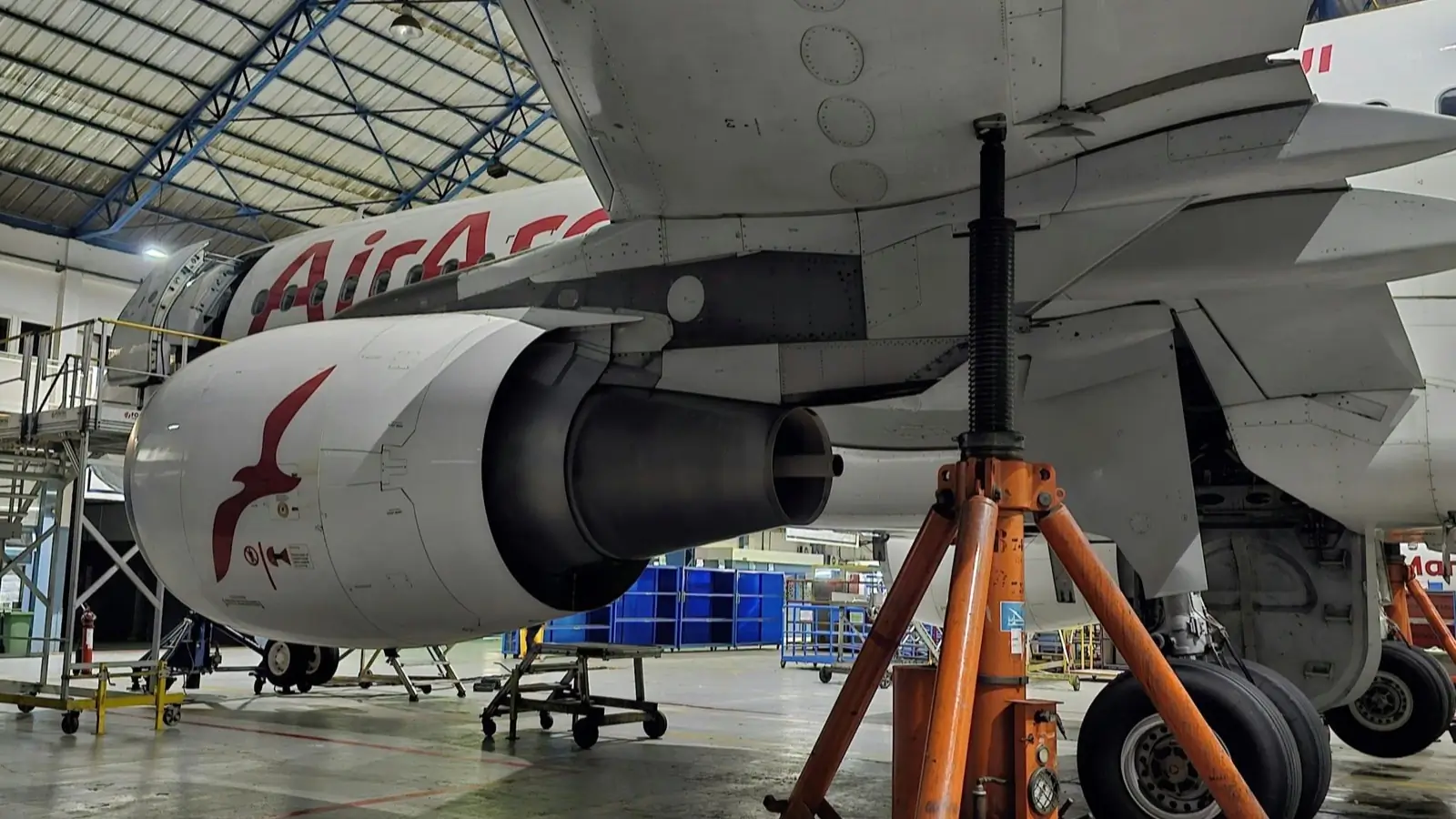 Commercial aircraft undergoing maintenance inside a service hangar